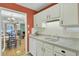 Bright kitchen with white cabinets, double sink, and view into dining area at 2757 Jobee Dr # 1101, Charleston, SC 29414