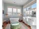 Elegant bathroom with soaking tub, double vanity, and hardwood floors at 4001 Palm Blvd, Isle of Palms, SC 29451