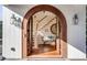 Bright entryway with arched wood door and hardwood floors leading to staircase at 4001 Palm Blvd, Isle of Palms, SC 29451