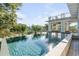 Stunning infinity pool with surrounding deck and lush landscape at 4001 Palm Blvd, Isle of Palms, SC 29451