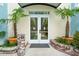 Welcoming entrance with double doors, flanked by tropical plants in pots at 5804 Palmetto Dr # A-405/407, Isle of Palms, SC 29451