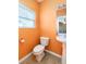 Small bathroom with orange walls, white toilet and sink at 7468 Northgate Dr, Hanahan, SC 29410