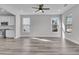 Open living room with hardwood floors, kitchen access, and large windows at 760 Myrtle Branch St, Summerville, SC 29486