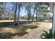 Spacious backyard with wooden fence, mature trees, and a swing set at 9504 Markley Blvd, Summerville, SC 29485