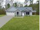 Gray brick home with white garage door and landscaped lawn at 1034 Weeks Lane, Round O, SC 29474