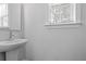 Small bathroom with pedestal sink, mirror, and window with blinds at 2129 Blue Bayou Blvd, Johns Island, SC 29455