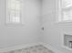 Laundry room with tile floors, shelving, and two windows for natural light at 2129 Blue Bayou Blvd, Johns Island, SC 29455