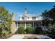 White two-story home with a metal roof, screened porch, and brick chimneys at 222 Haddrell St, Mount Pleasant, SC 29464