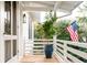 Screened porch with white railings, potted plant, and American flag at 222 Haddrell St, Mount Pleasant, SC 29464