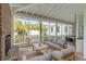 Relaxing screened porch with brick fireplace and wooden furniture at 222 Haddrell St, Mount Pleasant, SC 29464