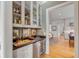 Wet bar with glass-front cabinets,wine cooler, and granite countertop at 222 Haddrell St, Mount Pleasant, SC 29464