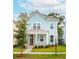 Charming light blue two-story house with a front porch and well-manicured lawn at 2253 Blue Bayou Blvd, Johns Island, SC 29455