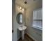 Small bathroom with pedestal sink, round mirror, and window with blinds at 413 Trotters Ln, Moncks Corner, SC 29461