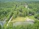 Aerial view showing home nestled in trees near a pond at 820 Pineneedle Way, Charleston, SC 29492