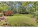 Large grassy backyard with mature trees and wooden deck at 820 Pineneedle Way, Charleston, SC 29492