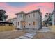 Two-story home with gray siding and a backyard patio at sunset at 929 Rutledge Ave, Charleston, SC 29403