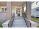 Front entrance with brick columns, metal railing, and a modern door at 929 Rutledge Ave, Charleston, SC 29403