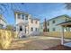 Rear view of a two-story house with light beige siding, a new patio, and a fenced backyard at 929 Rutledge Ave, Charleston, SC 29403