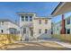Rear view of a two-story house with light beige siding, a new patio, and a fenced backyard at 929 Rutledge Ave, Charleston, SC 29403
