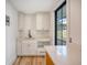 Laundry room with white cabinets, quartz countertops, and a farmhouse sink at 929 Rutledge Ave, Charleston, SC 29403