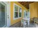 Charming patio area with a table, chairs, and a view of the bright yellow home exterior at 1014 Rosewood Ln, Mount Pleasant, SC 29464