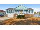 Charming light teal house with brick accents, a large front porch, and a well-manicured lawn at 1336 Battle Ground Rd, Charleston, SC 29412