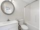 Bright bathroom features a vanity with a round mirror, a toilet, and a shower-tub combo at 139 Blue Jasmine Ln, Summerville, SC 29483