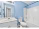 Bright bathroom features a vanity with a round mirror, a toilet, and a shower-tub combo at 139 Blue Jasmine Ln, Summerville, SC 29483