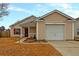 Beige house with a white garage door and landscaping at 139 Blue Jasmine Ln, Summerville, SC 29483