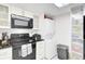 White cabinets, black appliances, and stackable washer/dryer at 14 Lockwood Dr # 6H, Charleston, SC 29401