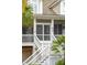 White staircase leading to a screened porch with black shutters at 15 31St Ave, Isle of Palms, SC 29451