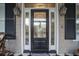 Black front door with sidelights and a decorative glass inset at 15 31St Ave, Isle of Palms, SC 29451