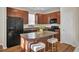Modern kitchen with dark wood cabinets, black appliances, and an island at 153 Instructor Ct, Ladson, SC 29456
