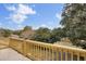 Deck with wooden railing offering scenic views of neighborhood and trees at 1661 Battalion Dr, Charleston, SC 29412