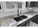 Granite countertop kitchen sink with black faucet and white speckled countertop at 1661 Battalion Dr, Charleston, SC 29412