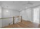 Hallway with hardwood floors, a white railing, and a contemporary chandelier at 1892 Grover Rd, Johns Island, SC 29455