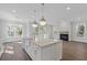 Open concept floor plan with kitchen island, stainless steel appliances, and fireplace at 1892 Grover Rd, Johns Island, SC 29455