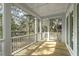 Bright porch with white beams and white railings and view of wooded yard at 1892 Grover Rd, Johns Island, SC 29455