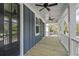 Covered porch featuring a ceiling fan, wood floors, and blue siding at 1894 Grover Rd, Johns Island, SC 29455