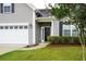 House entrance with dark door, landscaping, and white garage at 207 Loocock Dr, Goose Creek, SC 29445