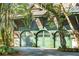 Three-car garage with green doors and metal roof at 26 Cormorant Island Ln, Kiawah Island, SC 29455