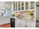 Kitchen wet bar with white cabinets and wine cooler at 26 Cormorant Island Ln, Kiawah Island, SC 29455