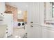 Bright laundry room with white cabinets and patterned wallpaper at 26 Cormorant Island Ln, Kiawah Island, SC 29455