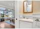 Powder room with white vanity, decorative mirror, and yellow patterned wallpaper at 26 Cormorant Island Ln, Kiawah Island, SC 29455