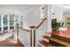 Elegant staircase with white railings and rich hardwood floors at 26 Cormorant Island Ln, Kiawah Island, SC 29455