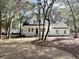 Two-story white farmhouse with a landscaped yard and mature trees at 3315 Hopkinson Plantation Rd, Johns Island, SC 29455