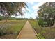 Long wooden boardwalk leading to a picturesque waterfront at 4007 Capensis Ln, Ravenel, SC 29470