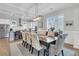 Elegant dining room with large table, chandelier, and adjacent kitchen at 4007 Capensis Ln, Ravenel, SC 29470