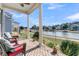Brick porch with seating area overlooking pond at 4007 Capensis Ln, Ravenel, SC 29470