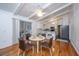 Bright dining area with white table and four brown chairs, hardwood floors and kitchen view at 411 Constance St, Walterboro, SC 29488